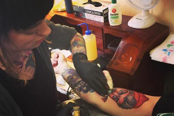 Lucy O' Connell Tattoo artist, tattooing a clients arm