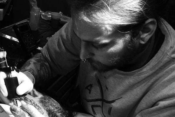 Pabole Sinalma tattoo artist, tattooing a client