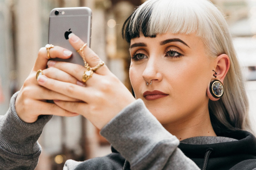 A women wearing wooden ear gauges as the best material for stretching ears