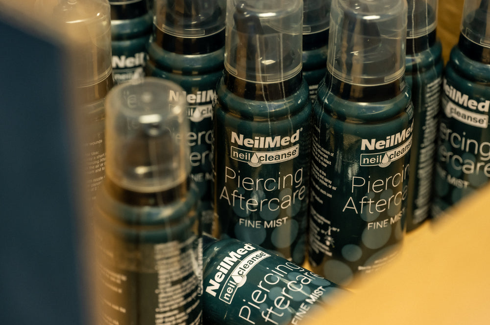 A large collection display of NielMed Piercing Aftercare Spray