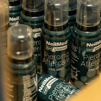 A large collection display of NielMed Piercing Aftercare Spray