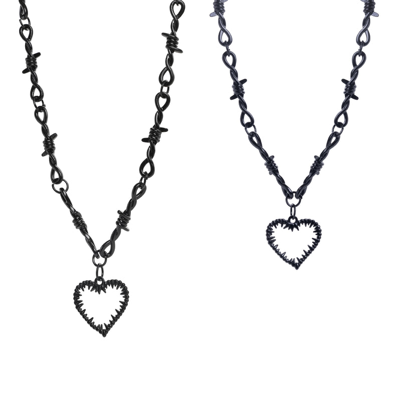 Deux colliers en fil barbelé avec pendentifs cœur sur fond blanc