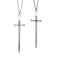 Two colliers épée argentés avec pendentifs en acier inoxydable, l’un à pointe et l’autre à extrémité plate, tous deux sur des chaînes argentées.