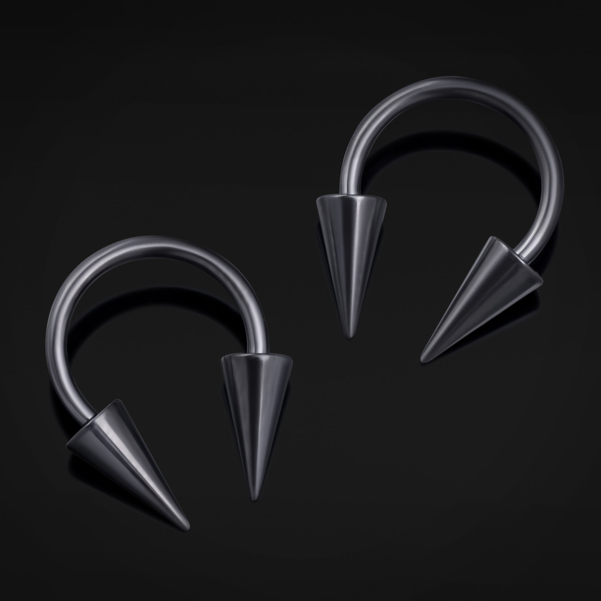Pair of metallic hoop earrings with spike details on a black background