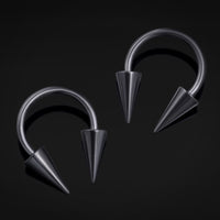 Pair of metallic hoop earrings with spike details on a black background